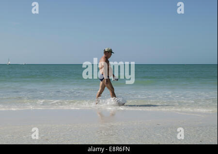 Ein einziger übergewichtiger Mann in Badehosen und Schienbeinen, der in der Brandung, Sarasota County, Florida, Golfküste, USA, läuft Stockfoto