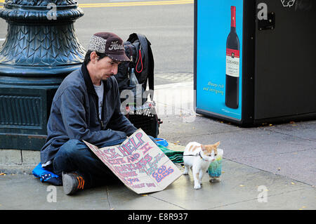 Chicago Obdachloser Mann sitzt mit seiner Katze (angeleint) und melden Sie an Straßenecke. Wein Werbung entgegen in Erwägung gezogen werden. Stockfoto