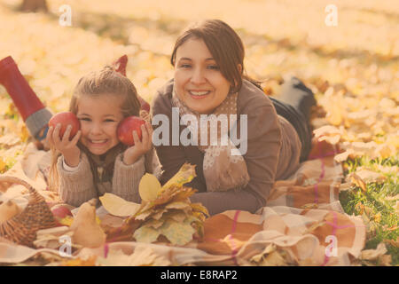 Glückliche junge Mutter mit Tochter auf Herbst Picknick Stockfoto