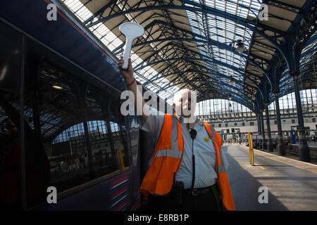 Ein Signal-Mann am Bahnhof von Brighton bereitet seine Pfeife zu Blasen, um die Treiber wegzuziehen benachrichtigt. Stockfoto