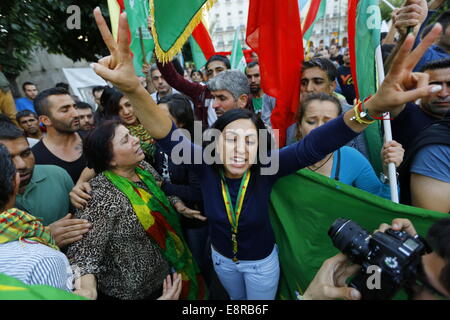 Athen, Griechenland. 13. Oktober 2014. Ein weiblicher Demonstrant macht einen Sieg in Richtung der Fotografen zu unterzeichnen. Kurden leben in Griechenland protestierte gegen die Angriffe des islamischen Staates (IS) auf die Stadt Kobane in Syrien. Ihre Wut richtete sich vor allem in Richtung Türkei und die Untätigkeit der türkischen Armee, auf die Hilfe von der belagerten Stadt zu kommen. Stockfoto