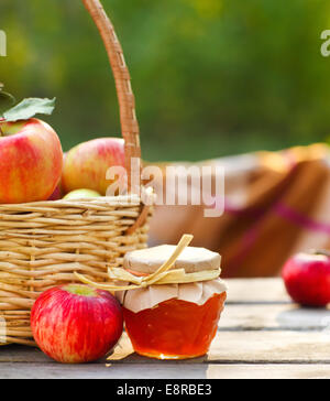 Äpfel in einem Korb auf Holztisch Garten Hintergrund Stockfoto