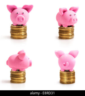 Vier kleine rosa Schweinchen auf Münzen. Isoliert auf weiss Stockfoto