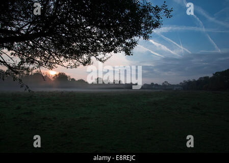 Oktober 2014: Am frühen Morgen neblige Landschaft mit Flugzeuge Kondensstreifen am blauen Himmel. In Oxford, England Stockfoto