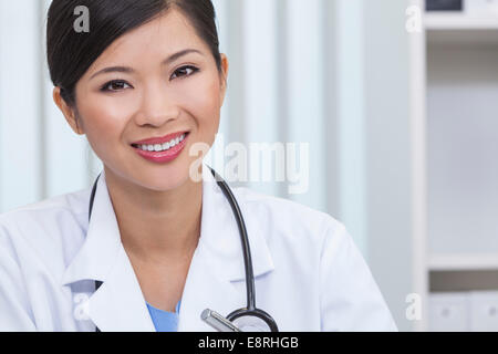 Ein Lächeln auf den Lippen glücklich chinesischen asiatischen weiblichen Arzt in einem Krankenhaus-Büro Stockfoto