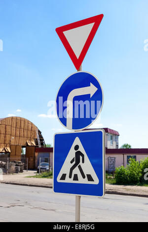 Triangular, Runde und quadratische Verkehrszeichen vor blauem Himmel Stockfoto