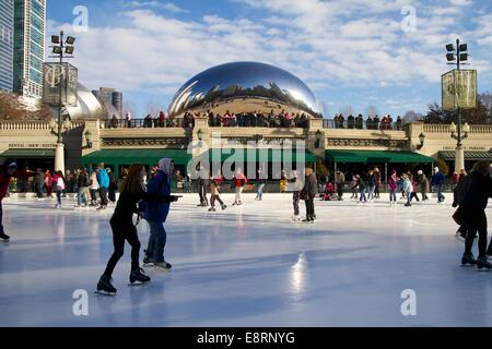 Eisläufer skate McCormick Tribune Ice Rink, Skulptur Cloud Gate im Hintergrund. Millennium Park, Chicago, Illinois. Stockfoto