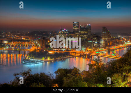 Der Himmel leuchtet Orange während der Morgendämmerung in der letzten Stunde vor Sonnenaufgang über der Innenstadt von Pittsburgh, Pennsylvania. Stockfoto