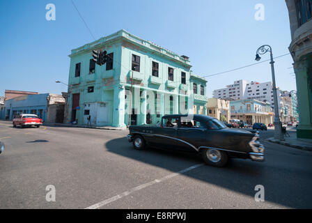 Zwei amerikanische Oldtimer Geschwindigkeit über eine Kreuzung in einem zentralen Viertel von Havanna. Stockfoto