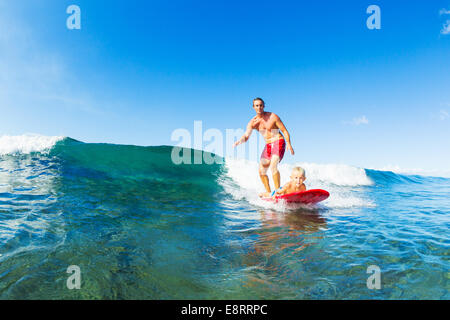 Vater und Sohn Surfen zusammen. Welle mit Surfbrett Tandem. Vaterschaft, Familie Spaß Outdoor-Lifestyle. Stockfoto