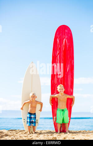 Süße junge Jungs mit Surfbrettern am Strand von Hawaii. Gehen surfen. Stockfoto