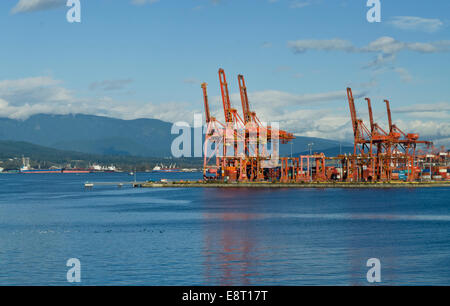 Ladekranen für Containerschiffe im Hafen von Vancouver, auf Burrard Inlet. Berge. Container terminal Hafen von Vancouver. Stockfoto