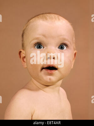 1960ER JAHRE BABY PORTRAIT GROßE AUGEN WUNDER GESICHTSAUSDRUCK BLICK IN DIE KAMERA Stockfoto