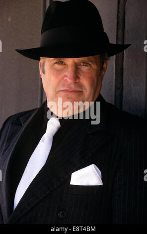 MANN IM SCHWARZEN ANZUG UND FEDORA Stockfoto