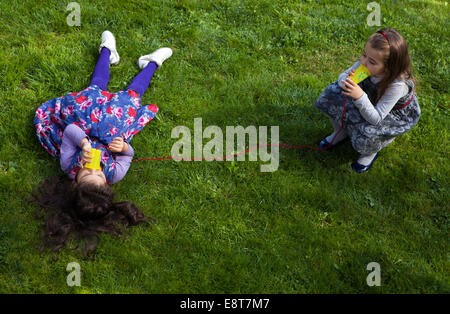 Zwei Mädchen spielen im Park mit Spielzeug Telefon Stockfoto