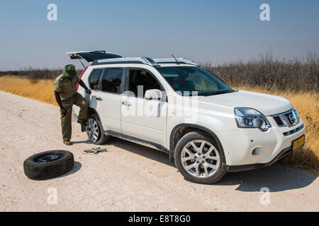 Afrikanische Wildhüter Reifenwechseln eines SUV, Etosha Nationalpark, Namibia Stockfoto