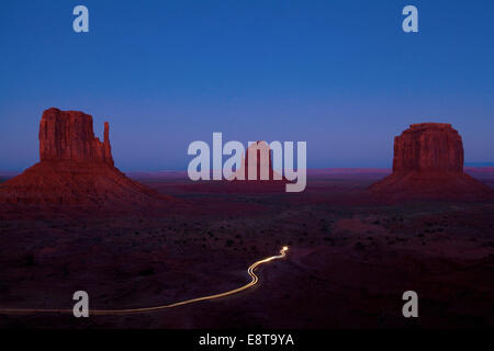 Langzeitbelichtung Autos vorbeifahren Butte Felsformationen in Wüstenlandschaft, Monument Valley Tribal Park, Utah, Vereinigte Staaten von Amerika Stockfoto