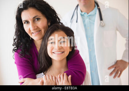 Hispanische Mutter und Tochter lächelnd mit Arzt Stockfoto