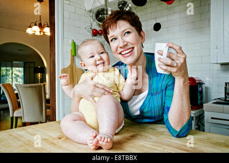 Kaukasische Mutter und Baby entspannend in Küche Stockfoto