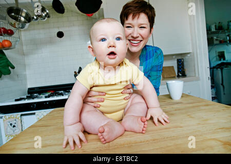 Kaukasische Mutter und Baby entspannend in Küche Stockfoto