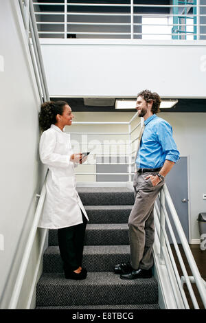 Arzt und Unternehmer sprechen auf Treppe Stockfoto
