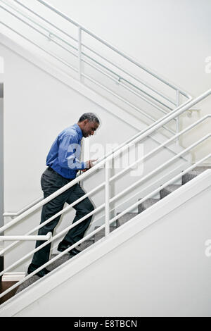 Schwarze Geschäftsmann kletternden Treppe Stockfoto