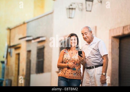 Hispanische Vater und Tochter mit Handy in Stadt Stockfoto
