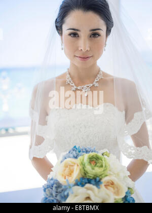 Mischlinge, asiatische / American Braut im weißen Hochzeitskleid am tropischen Strandhochzeit