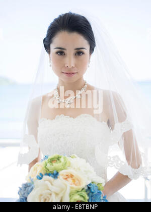 Mischlinge, asiatische / American Braut im weißen Hochzeitskleid am tropischen Strandhochzeit