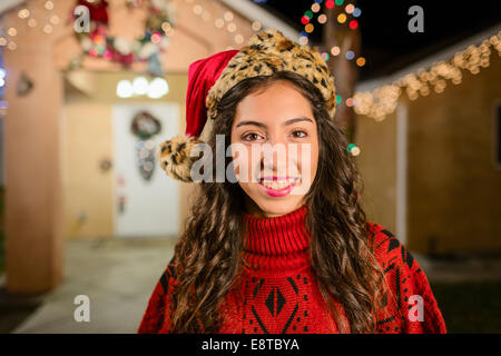 Hispanische vor Haus lächelnde Frau mit Lichterketten dekoriert Stockfoto