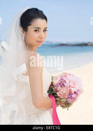 Mischlinge, asiatische / American Braut im weißen Hochzeitskleid am Strandhochzeit in Okinawa, Japan