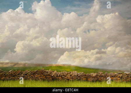 Steinmauer und Rasenflächen unter Wolken in ländlichen Landschaft Stockfoto