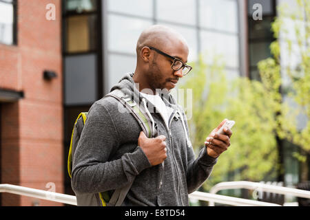 Schwarzer Mann mit Handy auf Stadtstraße Stockfoto