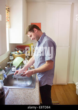 Kaukasischen Mann beim Abwasch in der Küche Stockfoto