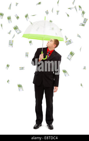 Junger Mann unter Dach, auf dem Geld-Regen von 100 Euro-Banknoten Stockfoto