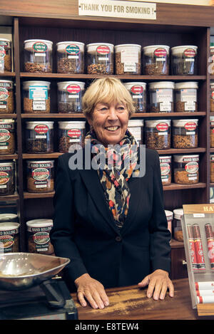 eine weibliche Tabakladen Dame verkauft, Tabak, Zigaretten, losen Tabak, Zigarren etc. aus ihrem Fachgeschäft in Brighton Stockfoto