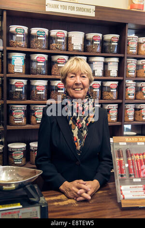 eine weibliche Tabakladen Dame verkauft, Tabak, Zigaretten, losen Tabak, Zigarren etc. aus ihrem Fachgeschäft in Brighton Stockfoto