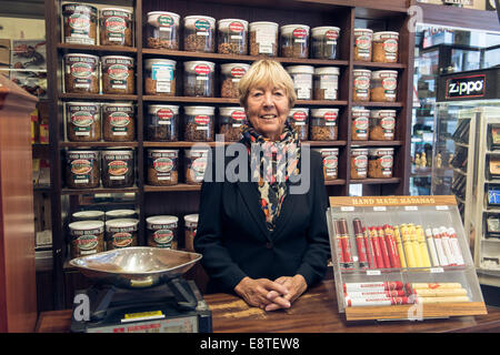 eine weibliche Tabakladen Dame verkauft, Tabak, Zigaretten, losen Tabak, Zigarren etc. aus ihrem Fachgeschäft in Brighton Stockfoto