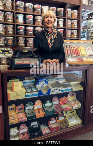 eine weibliche Tabakladen Dame verkauft, Tabak, Zigaretten, losen Tabak, Zigarren etc. aus ihrem Fachgeschäft in Brighton Stockfoto