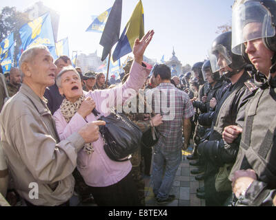 Kiew, Ukraine. 14. Oktober 2014. Ein paar stehen zwischen Ultra-radikale und der Polizei. Ukrainische Nationalisten haben Rauch-Kanister und Steinen bei Bereitschaftspolizei bei Zusammenstößen vor dem Parlament in Kiew geschleudert. Gewalt brach aus, als die Demonstranten forderten, dass MPs ein Gesetz verabschieden um einen zweiten Weltkrieges nationalistische Gruppe zu erkennen, die sowjetischen Streitkräfte gegen. 15 Polizisten wurden verletzt und mindestens 50 Demonstranten wurden verhaftet, des ukrainischen Innenministeriums sagte. M/s haben nicht gestimmt, der Kriegszeit ukrainischen Aufständischen Armee (UPA) zu erkennen. Bildnachweis: Igor Golovniov/ZUMA Draht/Alamy Live-Nachrichten Stockfoto