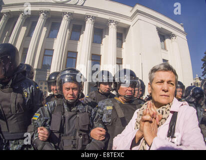 Kiew, Ukraine. 14. Oktober 2014. Eine Frau steht zwischen Ultra-radikalen und der Polizei. Ukrainische Nationalisten haben Rauch-Kanister und Steinen bei Bereitschaftspolizei bei Zusammenstößen vor dem Parlament in Kiew geschleudert. Gewalt brach aus, als die Demonstranten forderten, dass MPs ein Gesetz verabschieden um einen zweiten Weltkrieges nationalistische Gruppe zu erkennen, die sowjetischen Streitkräfte gegen. 15 Polizisten wurden verletzt und mindestens 50 Demonstranten wurden verhaftet, des ukrainischen Innenministeriums sagte. M/s haben nicht gestimmt, der Kriegszeit ukrainischen Aufständischen Armee (UPA) zu erkennen. Bildnachweis: Igor Golovniov/ZUMA Draht/Alamy Live-Nachrichten Stockfoto