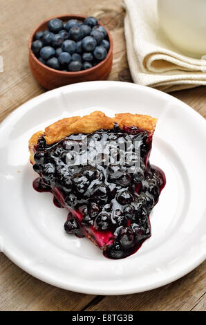 Stück Heidelbeerkuchen auf weißen Teller und frische Heidelbeeren Stockfoto