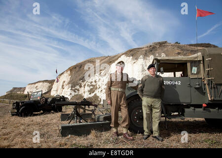 Zweiten Weltkrieg Armee Veteranen / Reenactors. stehend mit Waffen und Fahrzeuge in Schrift von den Kreidefelsen an Newhaven, Sussex Stockfoto