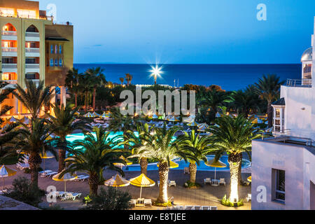 Dämmerung Blick auf den Poolbereich eines fünf-Sterne-Resort-Hotels in der Nähe von Port el Kantoui in Tunesien mit dem Mittelmeer. Stockfoto