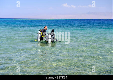 Taucher, die ins Meer zu Fuß vom seichten Strand Stockfoto