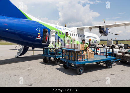 Gepäck ins Flugzeug für MAS Flügel Flug, Flughafen Miri, Malaysia geladen wird Stockfoto