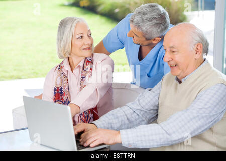 Hausmeister Blick auf ältere Frau von Mann mit Laptop Stockfoto