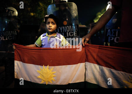 Thessaloniki, Griechenland. 14. Oktober 2014. Eine kurdische Kind hält einen kurdischen Flagge vor Aufruhr Polizisten, die den Eingang zum türkischen Konsulat bei einer pro-kurdischen Demonstration gegen Angriffe von islamischen Staat Aufständischen Ausrichtung auf die syrische Stadt Kobane in Thessaloniki, Griechenland am 14. Oktober 2014 zu blockieren. Bildnachweis: Konstantinos Tsakalidis/Alamy Live-Nachrichten Stockfoto