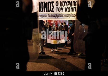 Thessaloniki, Griechenland. 14. Oktober 2014. Eine kurdische Kind hält einen kurdischen Flagge vor Aufruhr Polizisten, die den Eingang zum türkischen Konsulat bei einer pro-kurdischen Demonstration gegen Angriffe von islamischen Staat Aufständischen Ausrichtung auf die syrische Stadt Kobane in Thessaloniki, Griechenland am 14. Oktober 2014 zu blockieren. Bildnachweis: Konstantinos Tsakalidis/Alamy Live-Nachrichten Stockfoto