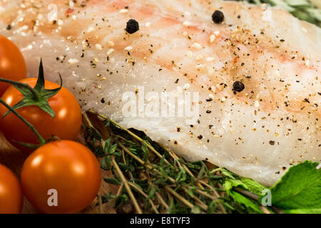 Filet vom frischen rohen Fisch mit Kräutern und Gewürzen Stockfoto